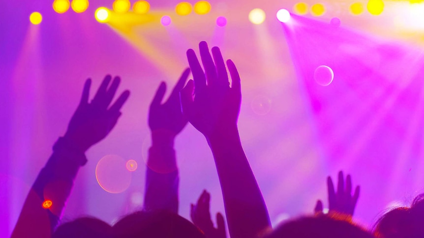 People's hands in the air in a night club setting for a story about the pros and cons of nightlife in a neighbourhood.