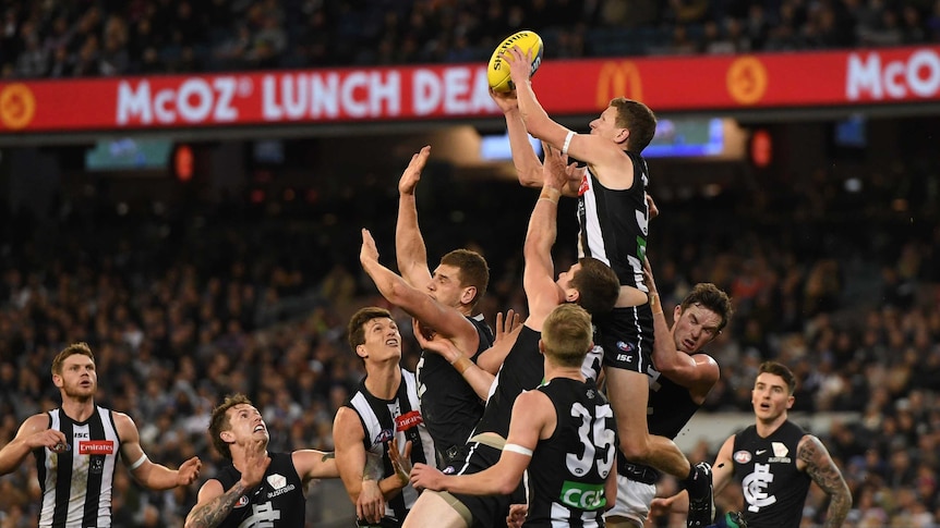 Will Hoskin-Elliot of the Magpies (3R) marks in front of goal against Carlton at the MCG.