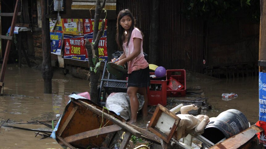 A girl searches for salvageable items after flash floods in Macasandig town, in southern Philippines.