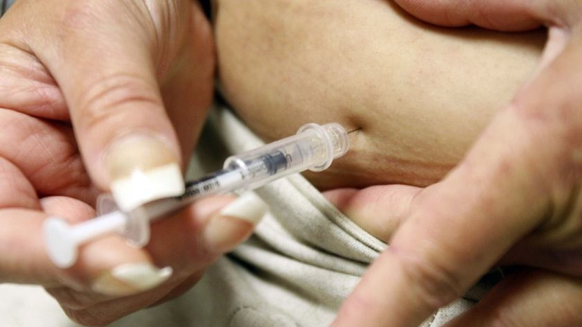 A diabetic injects herself with insulin