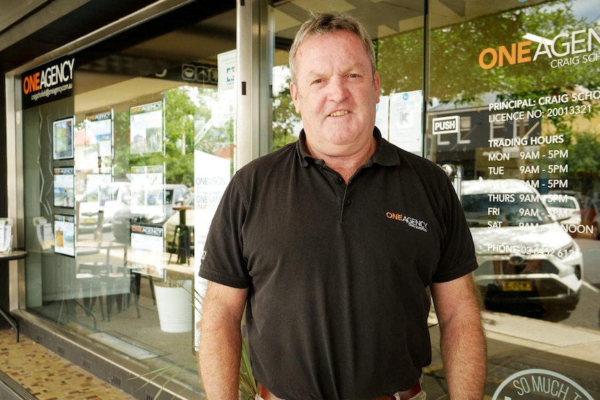 Real Estate agent Craig Schofield stands outside his agency