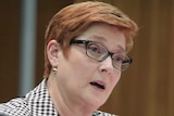 Marise Payne sits in front of a microphone in a wood-panelled room inside Parliament House