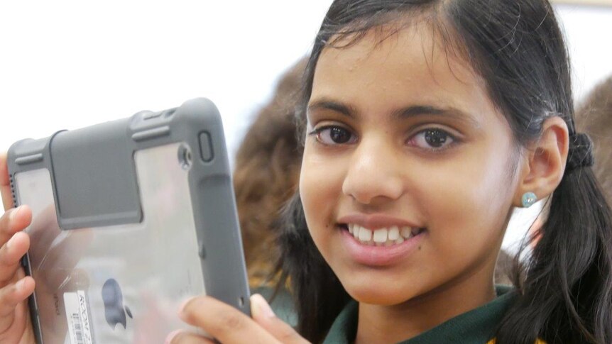 A primary school student looks at an iPad.