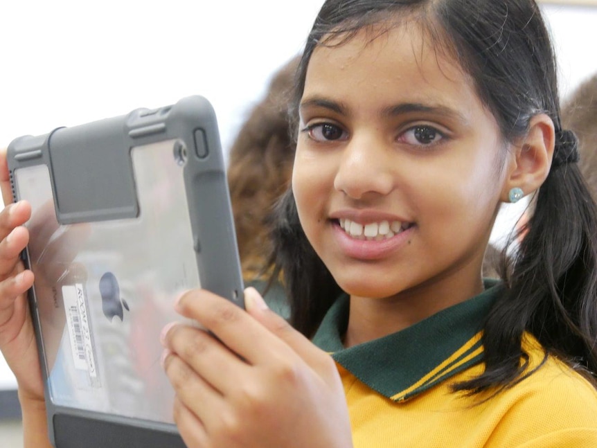 A primary school student looks at an iPad.