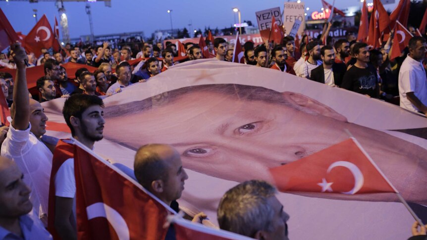 Supporters carry Turkish President Recep Tayyip Erdogan`s portrait during a rally.