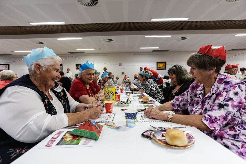 Barbara Templar (left) sitting at a long table with friends.