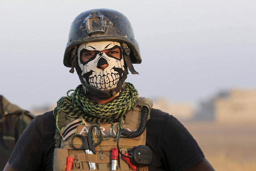 Soldier wears a skull mask.