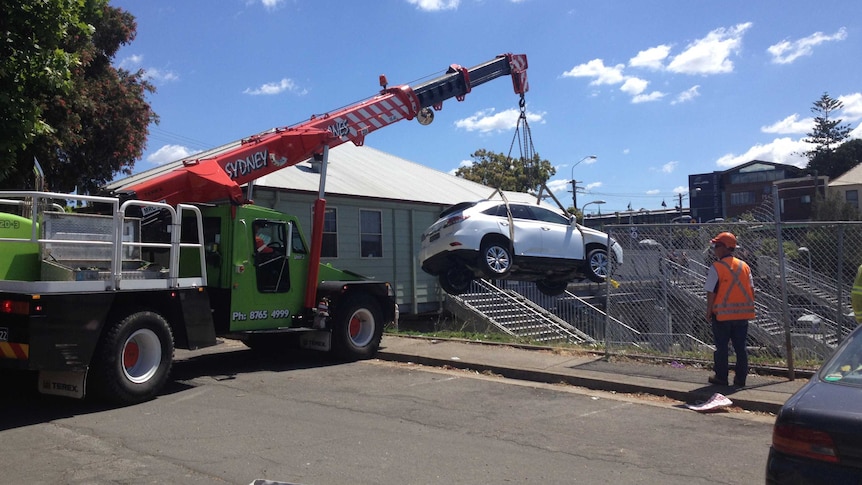 Large crane removed car from the platform of Croydon train station.