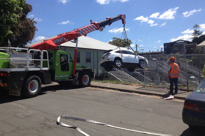 Large crane removed car from the platform of Croydon train station.