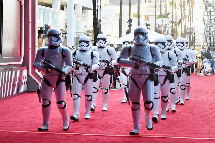 Two lines of Stormtroopers march down the red carpet at the premiere of "Star Wars: The Force Awakens".