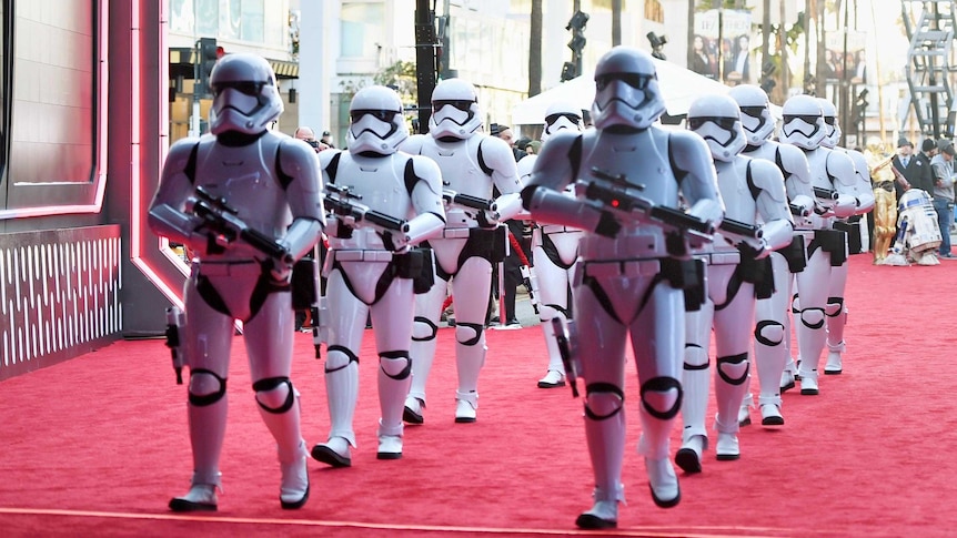 Two lines of Stormtroopers march down the red carpet at the premiere of "Star Wars: The Force Awakens".