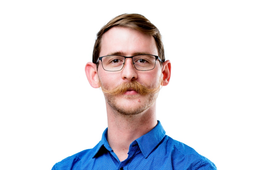 corporate headshot of man with handlebar moustache.