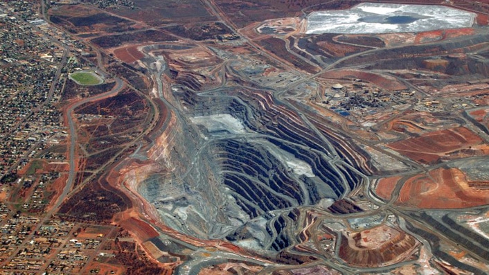 Aerial shot of the Kalgoorlie super pit surrounded by houses.
