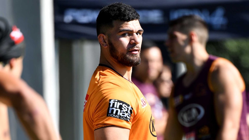 Another player prepares to pass the ball to David Fifita at Brisbane Broncos training.