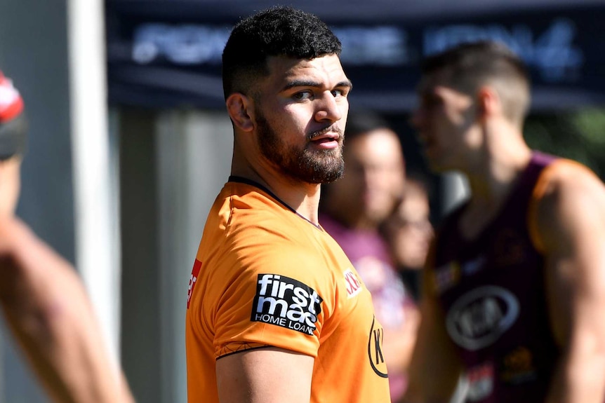 Another player prepares to pass the ball to David Fifita at Brisbane Broncos training.