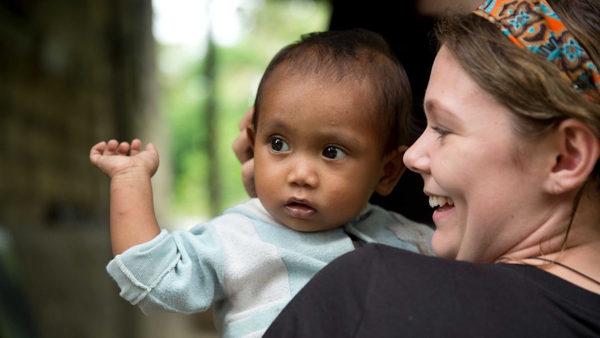 World Vision Youth Ambassador Claudia Bailey holds a baby during her recent trip to East Timor.