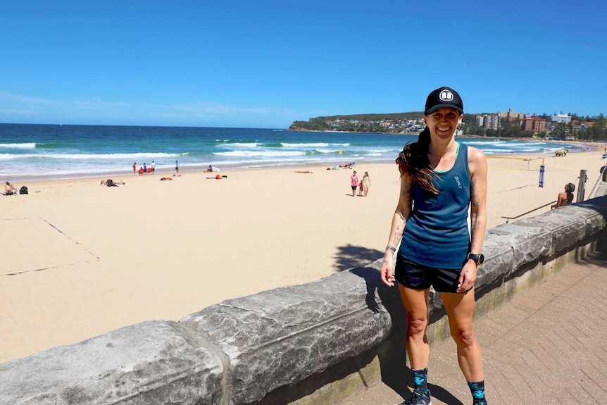 Hayley Blease standing by Manly beach in exercise gear.