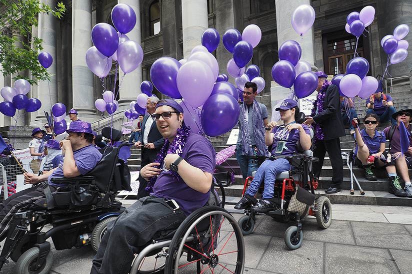 Nick Schumi in a wheelchair at State Parliament.