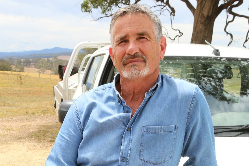 Ewan Waller poses for a photo by a ute on a rural property.