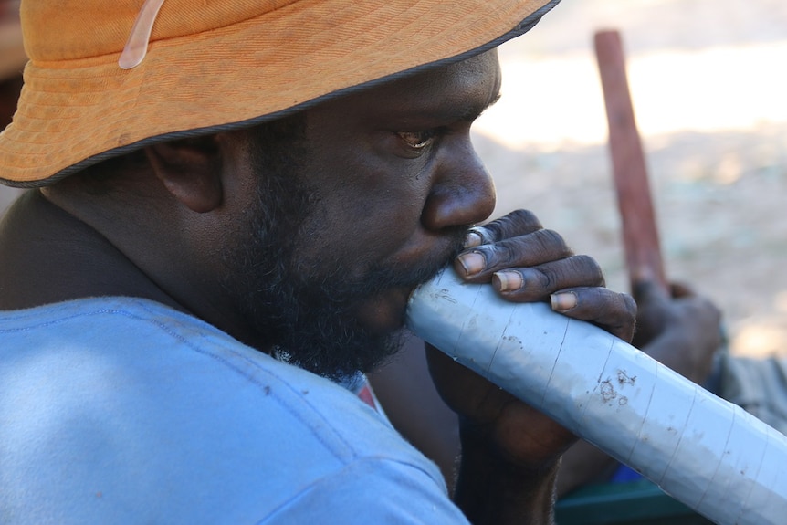 A man plays a yidaki as part of the ceremony.