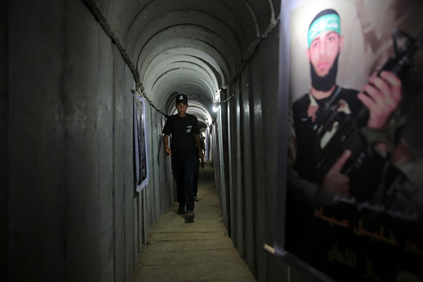 A Palestinian youth walks inside an underground tunnel.