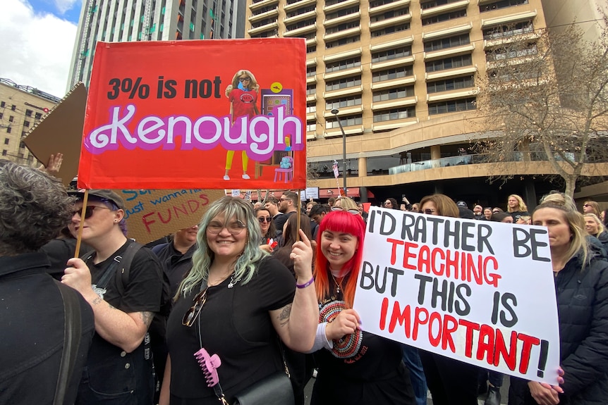 People at a protest hold a sign.