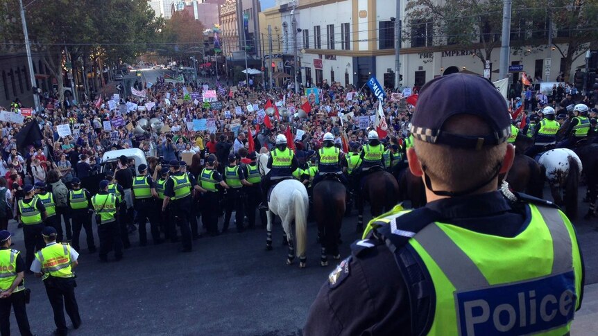 Police on horseback block protesters on the steps of parliament in Melbourne