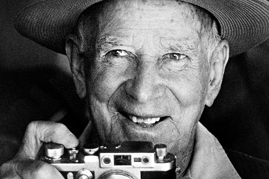 Frank Corley smiles while holding his camera