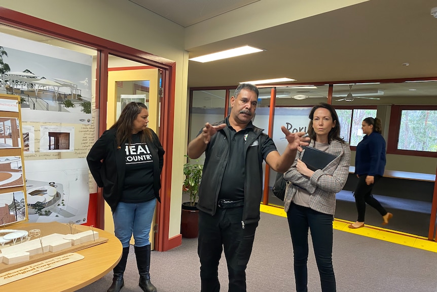 Three people tour a building.