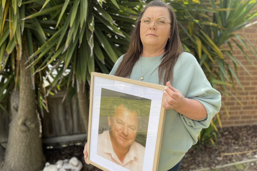 Woman holding photo of dead father.