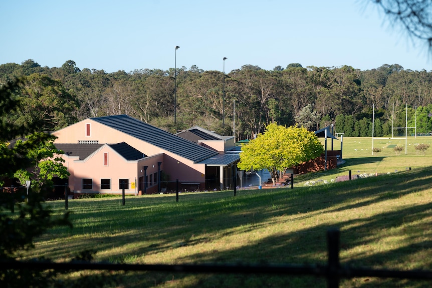 School buildings surrounded by grassy hills, basketball courts and football fields.