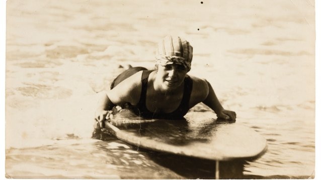 Young woman riding surfboard