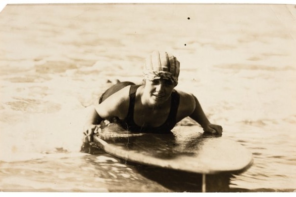 Young woman riding surfboard