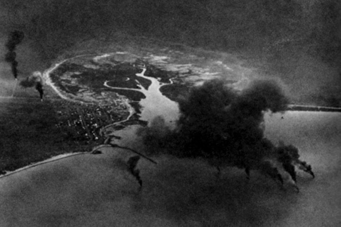 A black and white photo showing an explosion caused by an air raid.