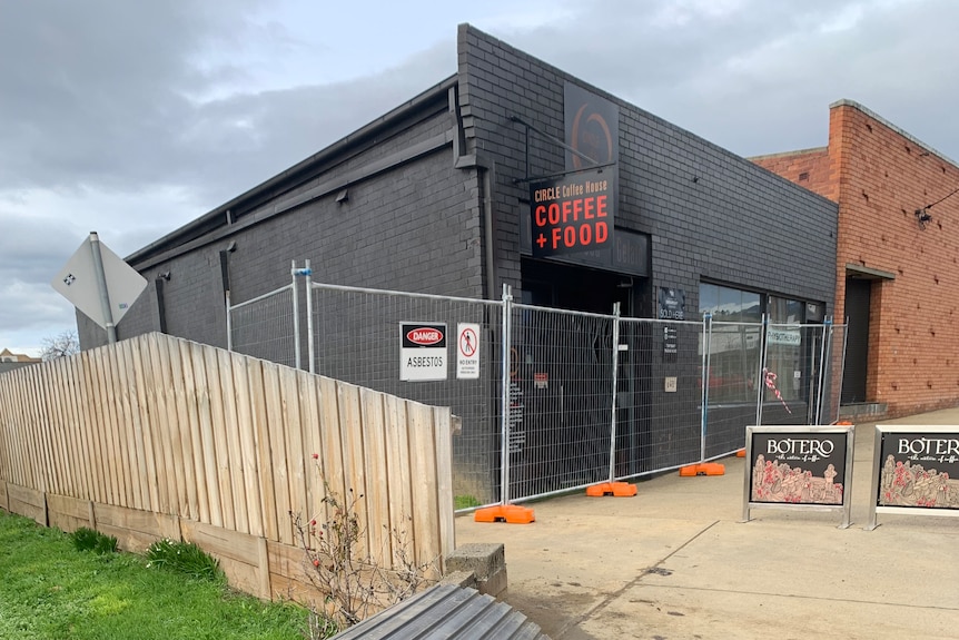 The cafe is fenced off after the blaze, and a piece of corrugated iron is visible in the foreground. 