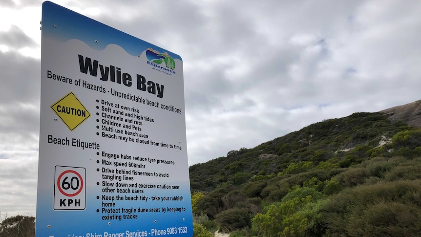 A sign posted at the entrance to a popular beach warning visitors about dangers.