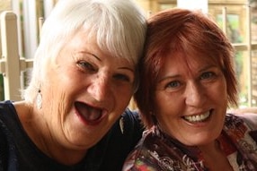 A head and shoulders photo of two women embracing