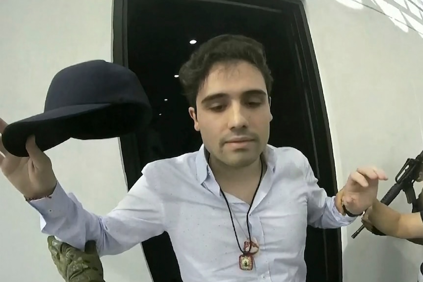 A young man holds up his hands during an arrest by Mexcian security forces.