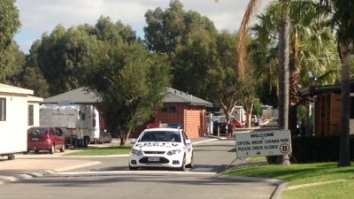 A police car block off an entrance to the Crystal Brook caravan park in Orange Grove this morning.