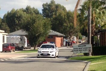 A police car block off an entrance to the Crystal Brook caravan park in Orange Grove this morning.