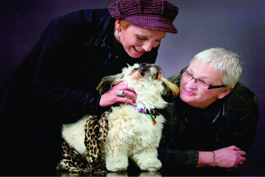 Cas Willow, left, pats a little white dog as Heather Richards watches on