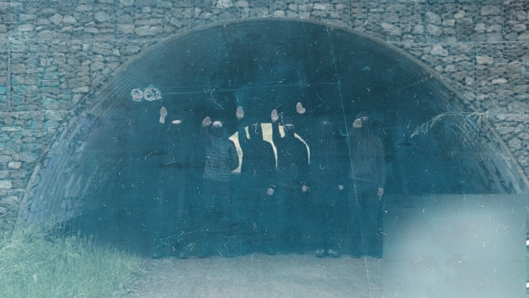 A group of young men in balaclavas give a fascist salute in a tunnel in Australia.