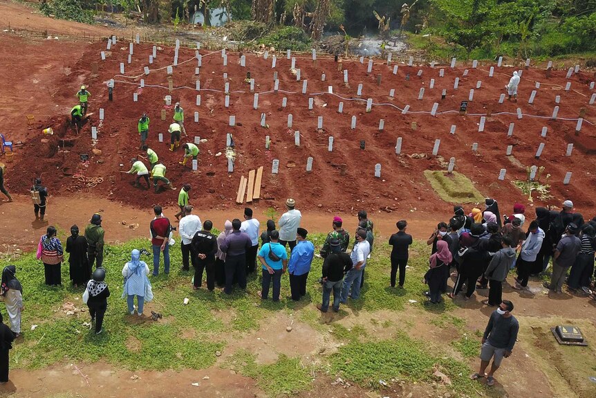 A group of people burying while another group watching it from a distance