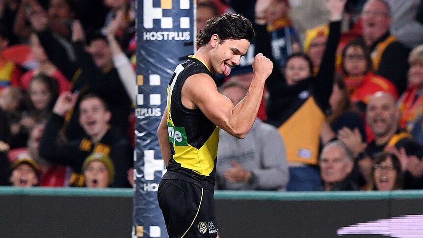Daniel Rioli pumps his fist and sticks his tongue out in celebration of a goal for Richmond.