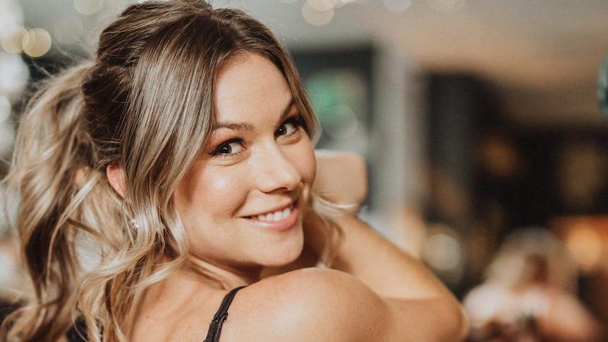Country singer Caitlin Shadbolt turns around to smile at the camera