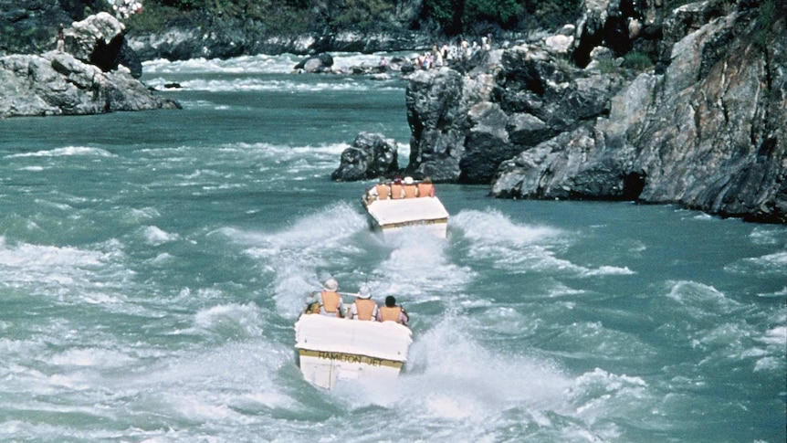 three jet boats battling their way up rapids in a gorge in Northern India