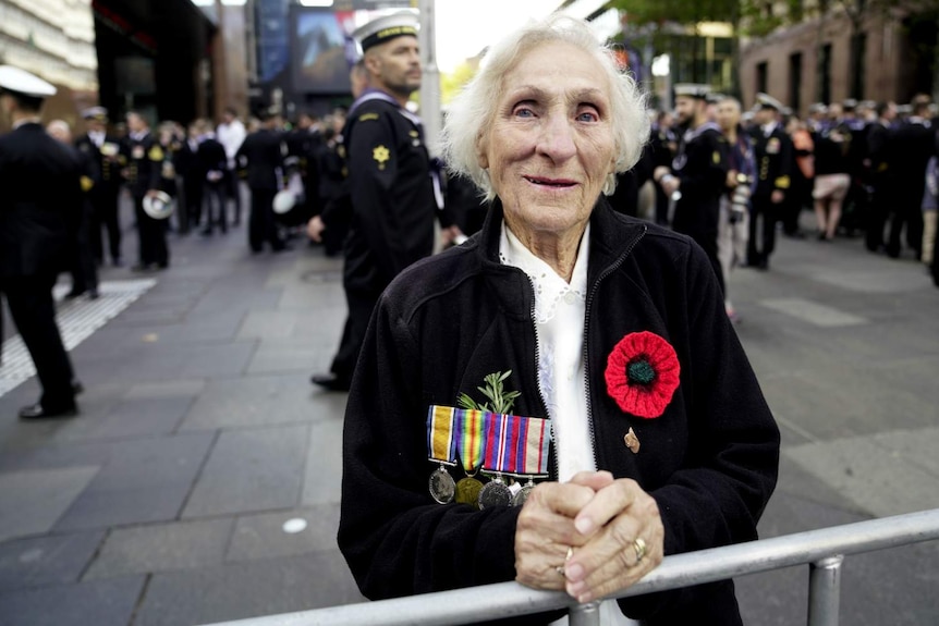 elderly woman with blue eyes wearing military medals staring at camera