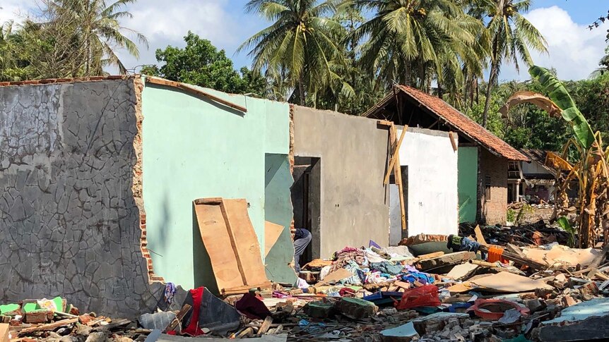 A roofless house surrounded by rubble.