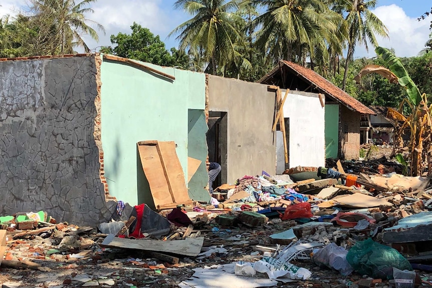 A roofless house surrounded by rubble.