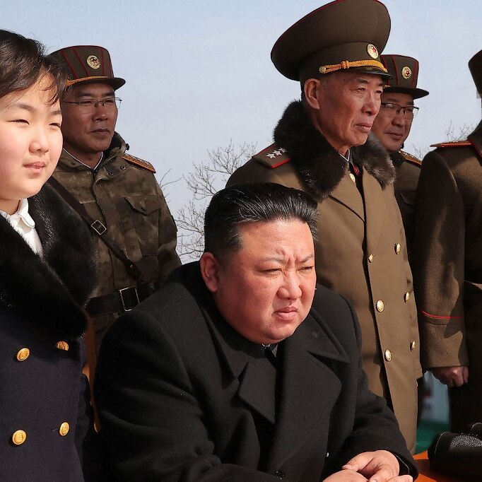 an image of Kim Ju Ae and Kim Jong Un along with military officials watching a missile launch